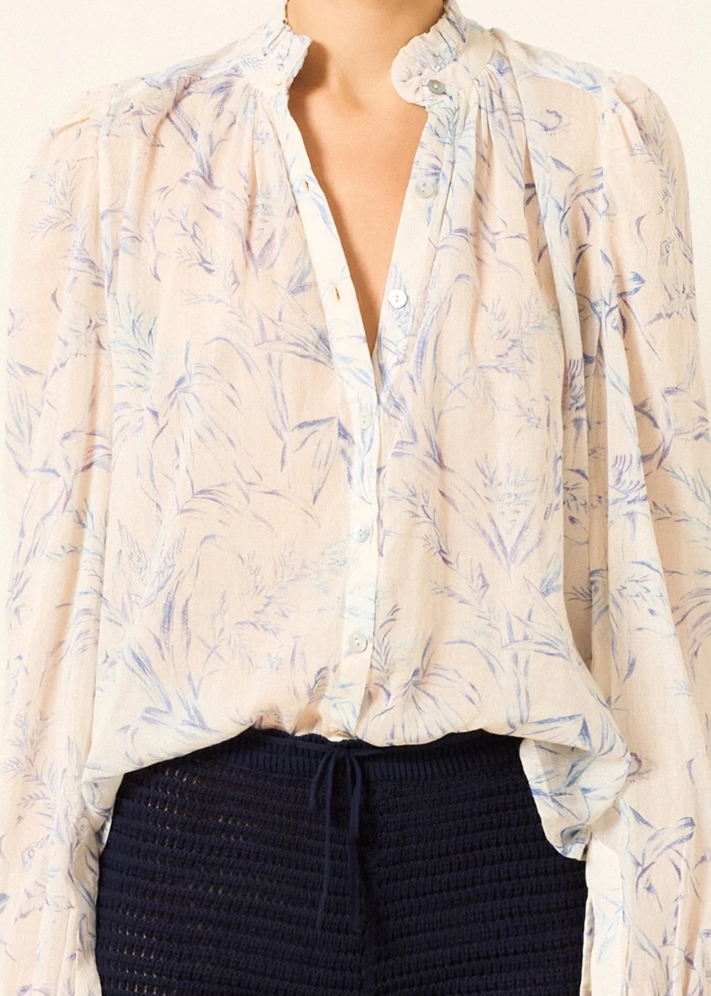 a sheer, long-sleeve button-up blouse by Alix Of Bohemia with a delicate blue and beige floral pattern