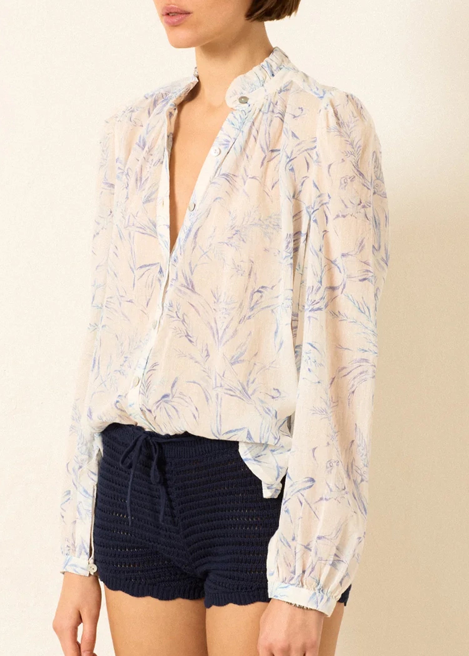 a sheer, long-sleeve button-up blouse by Alix Of Bohemia with a delicate blue and beige floral pattern