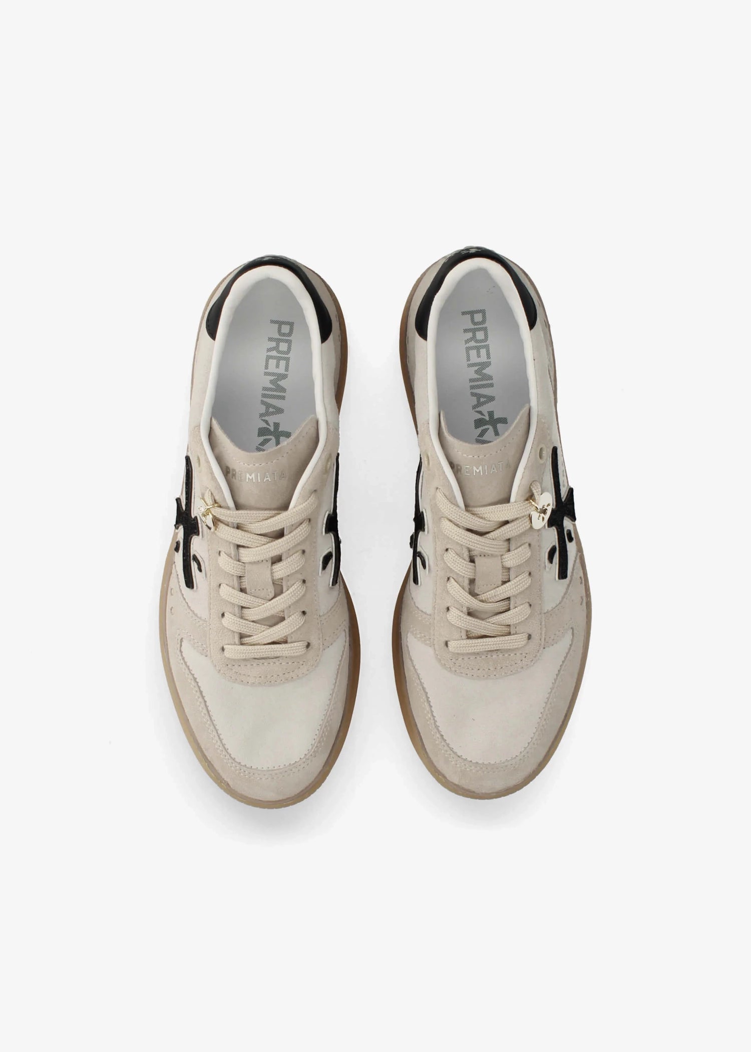 A low-top platform sneaker by Premiata, featuring a cream and beige suede and mesh upper, a black cross logo on the side, gold-tone hardware, and a thick tan gum sole.